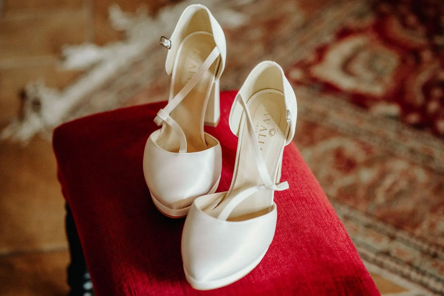 The bride's shoes on a red velvet stool