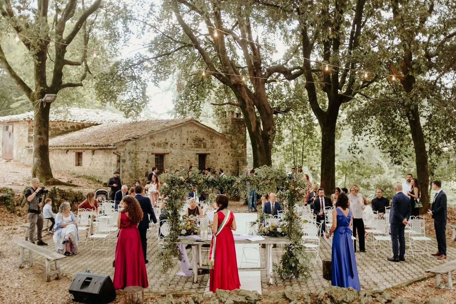 Guests taking their places for the ceremony under the trees of Borgo San Faustino