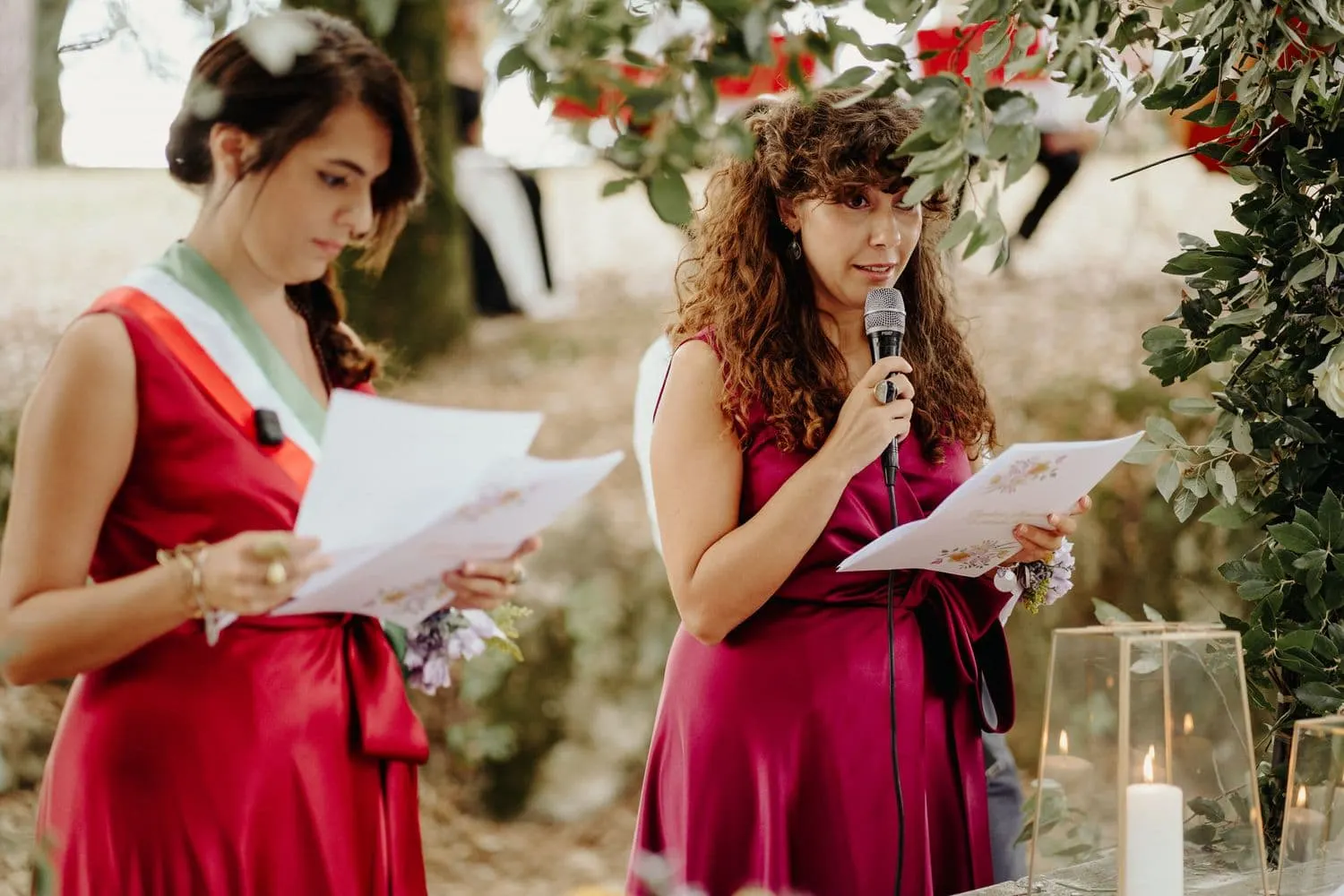 A reading at the microphone during the civil ceremony, beside the officiant in the tricolour sash