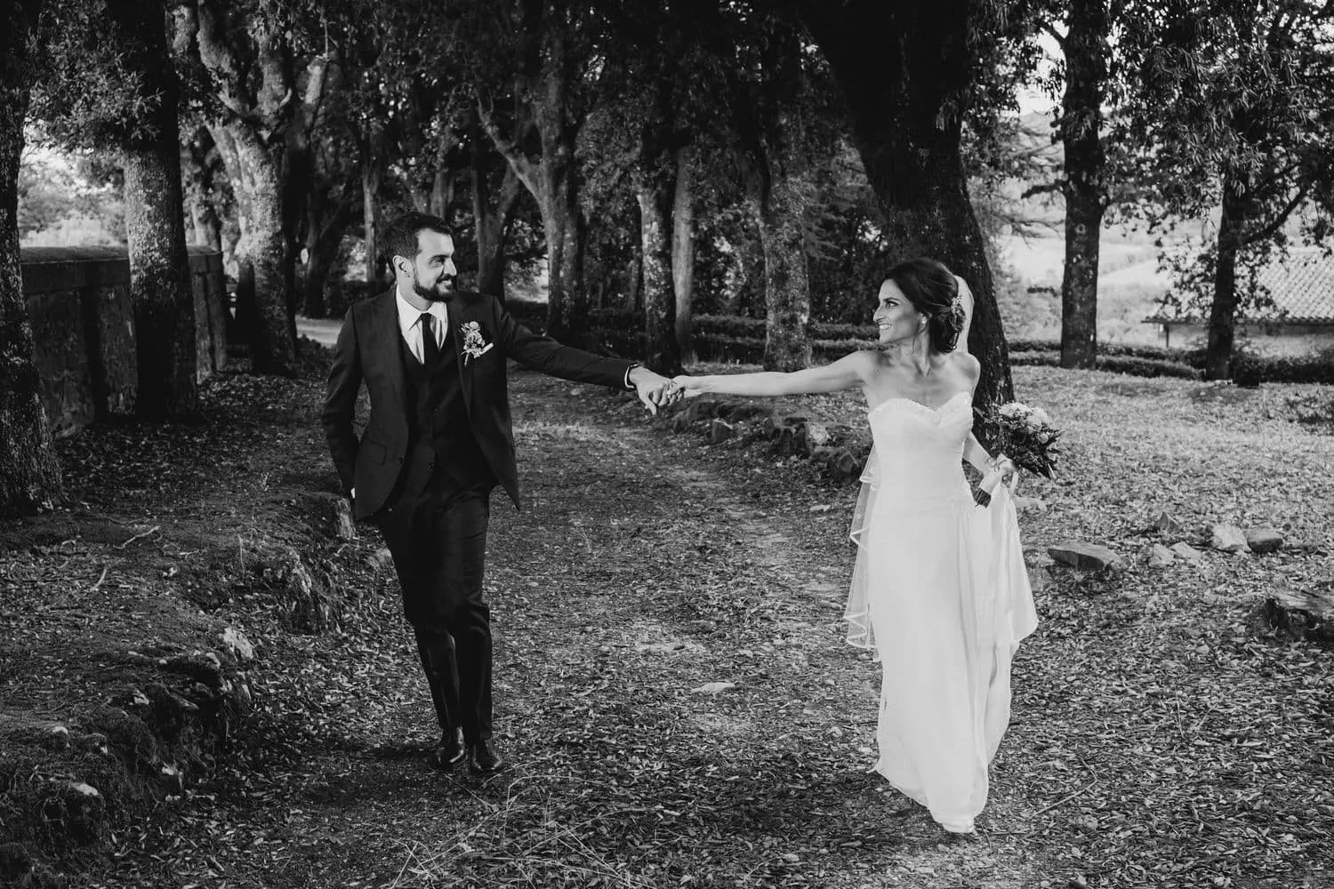 Francesco holding Giulia's hand in the estate's woods, in black and white