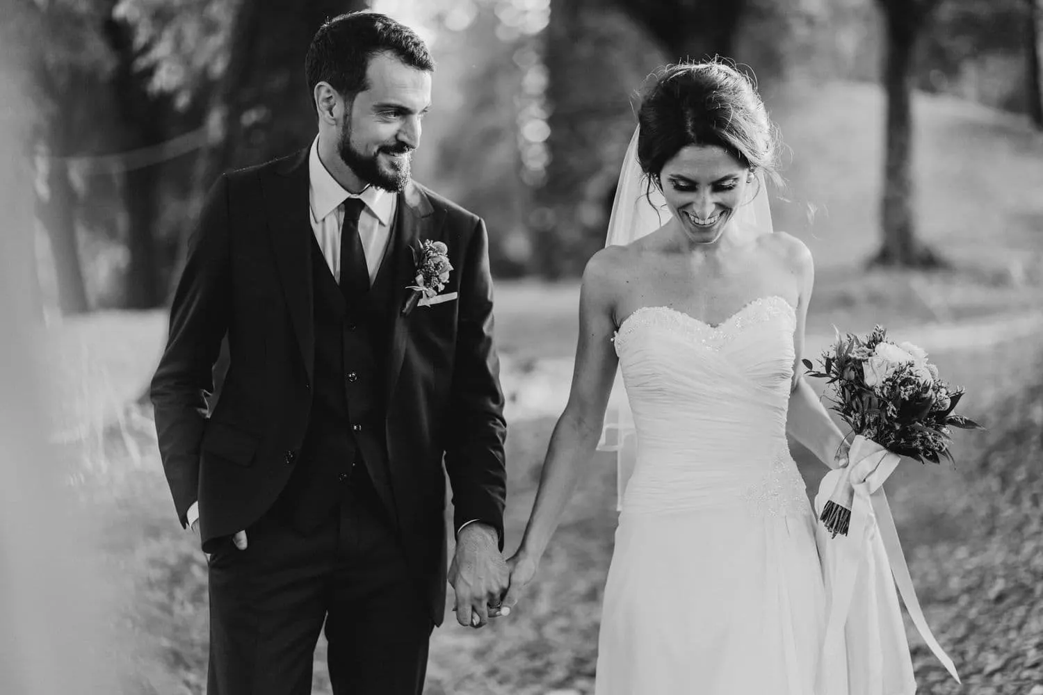 The couple walking hand in hand, in black and white